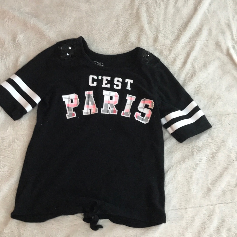 Black shirt, “c’est paris,” sequined shoulders.